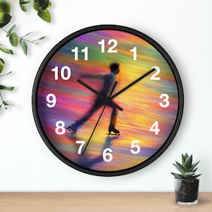 May include: Black-framed wall clock featuring a colorful, abstract background with a figure skater in motion. White numerals mark the hours. The clock hands are black. The background has shades of yellow, orange, pink, and blue.
