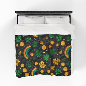 May include: A black comforter with a repeating pattern of gold coins, green shamrocks, gold flowers, and colorful rainbows. The bedding is on a black bed frame with white pillows.