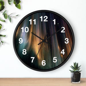 Puede incluir: Un reloj de pared redondo con marco negro. La esfera del reloj presenta un diseño abstracto colorido con tonos dorados, azules y morados. Los números blancos marcan las horas. El reloj está sobre una superficie de madera.