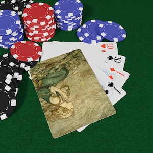 Puede incluir: Fichas de póquer en negro, rojo y azul apiladas sobre una superficie verde, junto a naipes. Las cartas muestran el número 10 e ilustraciones. La imagen tiene un tema de casino o noche de juegos.