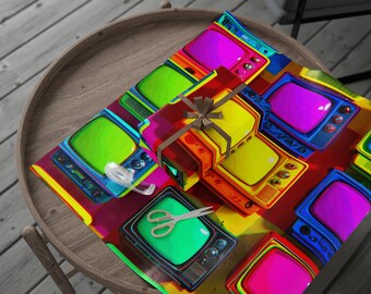 May include: A gift wrapped in colorful paper featuring a pattern of retro televisions in shades of green, yellow, pink, and blue. A wrapped gift box with a brown ribbon and scissors are on top of the wrapping paper. The scene is set on a wooden table.