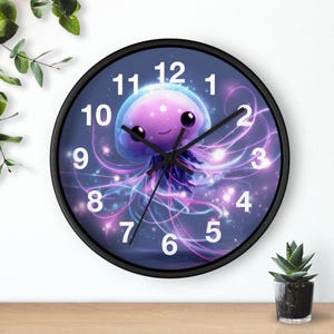 Puede incluir: Un reloj de pared redondo con marco negro. La esfera presenta una medusa de dibujos animados con cuerpo y tentáculos morados, sobre un fondo azul y morado. Los números blancos marcan las horas.