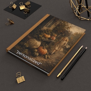 May include: A rectangular notebook with a brown spine and a cover featuring a vintage-style illustration of a child in a dress standing near pumpkins in a garden. The word "personalized" is printed in white text on the lower left corner.