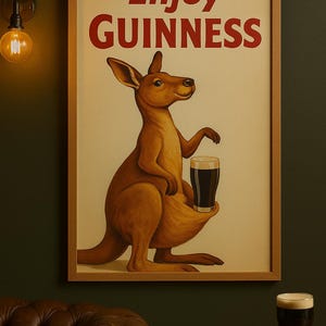 Puede incluir: Impresi&oacute;n enmarcada de estilo vintage con un canguro sosteniendo una pinta de Guinness. Las palabras "Enjoy Guinness" est&aacute;n en texto rojo en la parte superior. El canguro es marr&oacute;n y el fondo es de color crema.