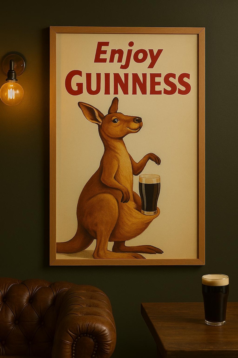 Puede incluir: Impresi&oacute;n enmarcada de estilo vintage con un canguro sosteniendo una pinta de Guinness. Las palabras "Enjoy Guinness" est&aacute;n en texto rojo en la parte superior. El canguro es marr&oacute;n y el fondo es de color crema.