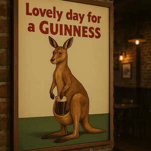 Puede incluir: P&oacute;ster enmarcado de estilo vintage con un canguro marr&oacute;n sosteniendo una pinta de Guinness. El texto "Lovely day for a GUINNESS" es rojo. El fondo es crema con una base verde. Marco de madera.