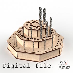 May include: A three-tiered wooden drill bit holder with multiple drill bits inserted. The holder is light brown with dark brown edges and has the text "Digital file". The holder is designed to organize drill bits of various sizes.