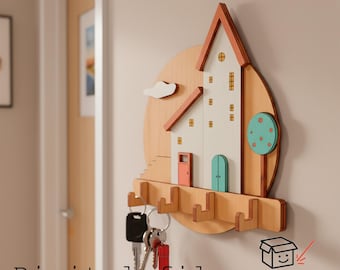 May include: Wooden house-shaped key holder with a white facade, red roof, and a teal door. The key holder has several hooks for keys and a tree and cloud design. The words "Digital file" are at the bottom left.