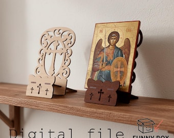 Puede incluir: Dos portadores de iconos de madera, uno de color claro con un diseño de cruz decorativo y otro de color oscuro que sostiene un icono de un ángel. La imagen está en un estante de madera. El texto "Digital file" es visible.