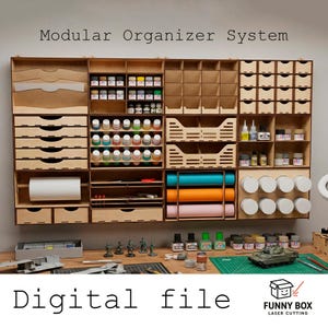 Op de afbeelding: Een modulair houten organisatiesysteem met meerdere compartimenten, laden en planken. Het bevat ruimtes voor verfpotten, papierrollen en andere knutselbenodigdheden. De tekst "Modular Organizer System" en "Digital file" zijn zichtbaar.