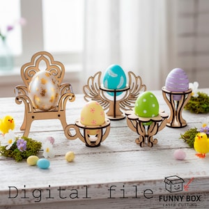 Op de afbeelding: Houten paaseierhouders in diverse ontwerpen, waaronder een stoel en een kopje. De eieren zijn beschilderd in pastelkleuren met patronen. De afbeelding bevat ook kleine decoratieve kuikens en bloemen.
