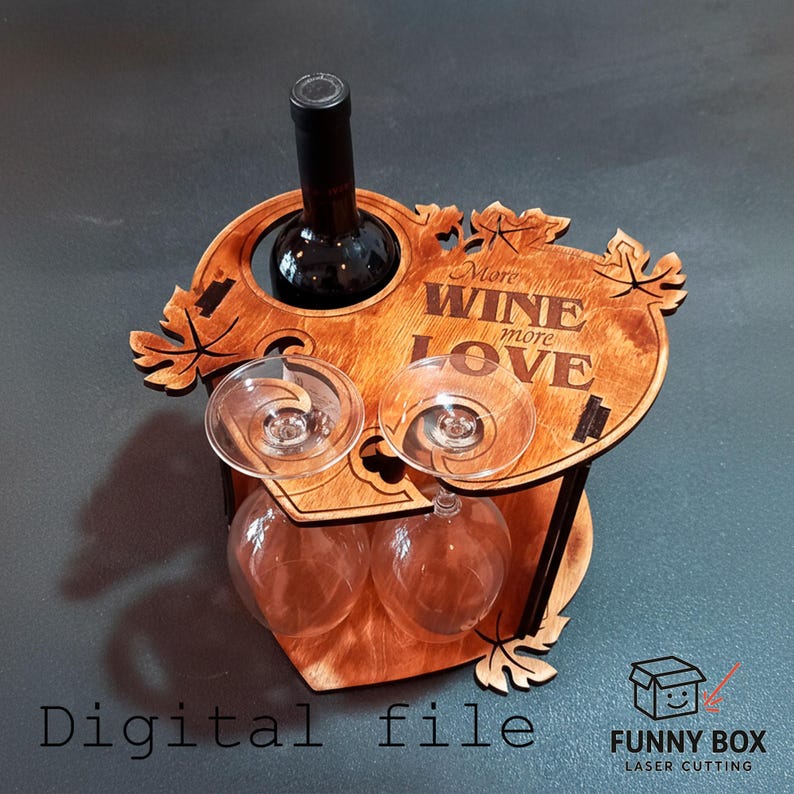 May include: Wooden wine bottle and glass holder with the text "More Wine More Love". The holder has a heart-shaped base and leaf accents. A wine bottle and two wine glasses are in place.