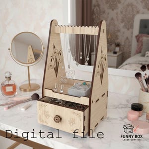 May include: A wooden jewelry organizer with a light brown finish. The organizer features a drawer, necklace hangers, and a small shelf for rings and earrings. The design includes floral engravings and the text "Digital file".