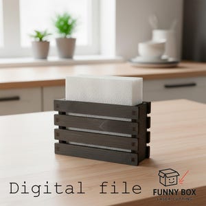 May include: A dark gray wooden napkin holder with a white napkin block inside. The holder has a slatted design and is on a light wood surface. The text "Digital file" is at the bottom.