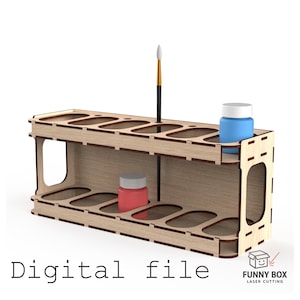 Puede incluir: Un soporte organizador de pintura de madera clara con dos niveles que presenta múltiples recortes ovalados para botes de pintura. El soporte sostiene un pincel, un bote de pintura azul y un bote de pintura rojo. El texto Digital file es visible.