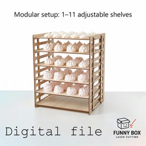 Op de afbeelding: Een houten rek met meerdere verstelbare planken, met talrijke witte meringues. Tekst op de afbeelding luidt "Modular setup: 1-11 adjustable shelves" en "Digital file". Het logo van Funny Box Laser Cutting staat rechtsonder.