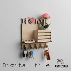 Può includere: Portachiavi in legno con la scritta "HOME" ritagliata, un cuore in rilievo e una piccola fioriera con una rosa rosa. Include ganci per chiavi e un ripiano per occhiali. Il testo "Digital file" è in basso.