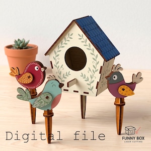 Könnte beinhalten: Ein Vogelhaus aus Holz mit blauem Dach und Blättermotiven, zusammen mit drei dekorativen Vogelsteckern aus Holz. Die Vögel sind rot, türkis und lila mit Mustern. Der Text "Digital file" ist sichtbar.