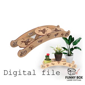 May include: A wooden plant stand with a tiered design, featuring laser-cut floral and leaf patterns. The stand holds potted plants, including a cactus, tulips, and a large-leafed plant. The words "Digital file" are visible.