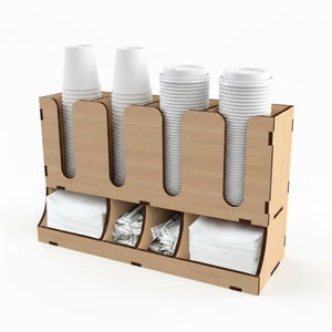 Può includere: Un organizer per postazione caffè in legno con quattro portabicchieri e tre scomparti per tovaglioli e condimenti. L'organizer contiene pile di bicchieri e coperchi di carta bianca, insieme a bustine di zucchero e tovaglioli.