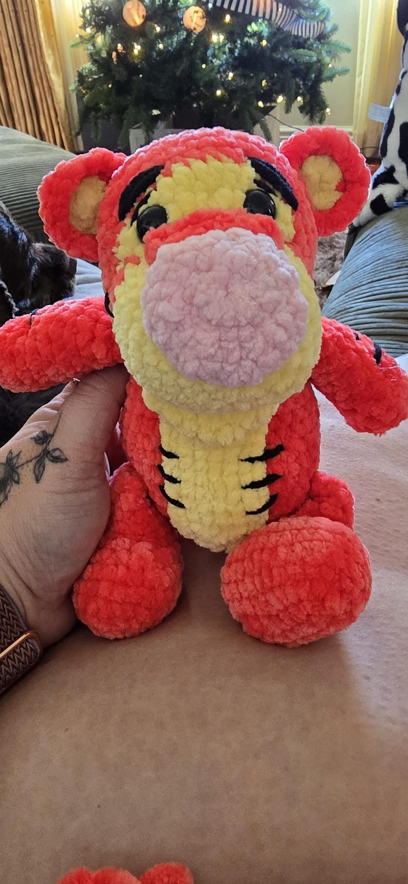 Puede incluir: Un peluche de tigre naranja y amarillo con una nariz rosa y rayas negras. El peluche tiene un aspecto suave y texturizado y probablemente est&aacute; hecho a mano. El juguete es un art&iacute;culo para ni&ntilde;os.