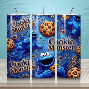 May include: Three stainless steel tumblers with a blue background featuring the Cookie Monster character and chocolate chip cookies. The tumblers have the words "Cookie Monster" in gold lettering. Each tumbler has a silver straw.