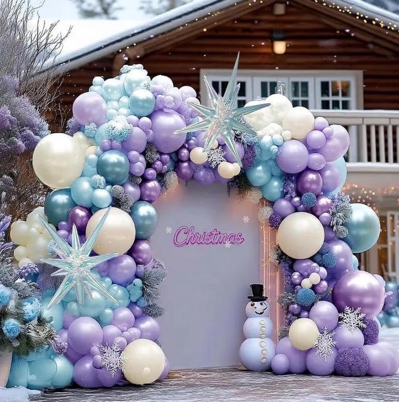 Puede incluir: Un arco navide&ntilde;o festivo hecho de globos en tonos pastel lavanda, azul y crema. El arco enmarca un tel&oacute;n de fondo con la palabra "Christmas" y un mu&ntilde;eco de nieve. Tambi&eacute;n se incluyen adornos decorativos en forma de estrella.