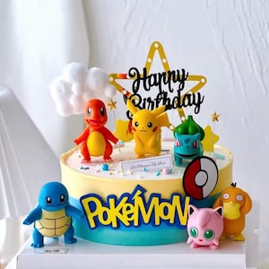 May include: A decorated cake featuring various Pokémon figurines, including Pikachu, Charmander, and Squirtle. The cake has a yellow and blue frosting with the Pokémon logo and a "Happy Birthday" topper.