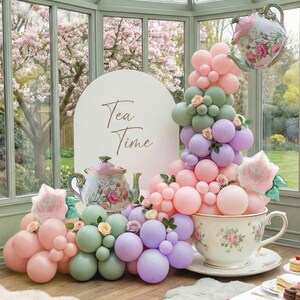 K&ouml;nnte beinhalten: Eine skurrile Teeparty-Szene mit einer gro&szlig;en Teetasse, die mit pastellfarbenen Luftballons &uuml;berquillt. Ein Schild mit der Aufschrift "Tea Time" und ein Teekannen-Ballon schweben dar&uuml;ber. Florale Akzente und eine dekorative Teekanne vervollst&auml;ndigen die Szene.