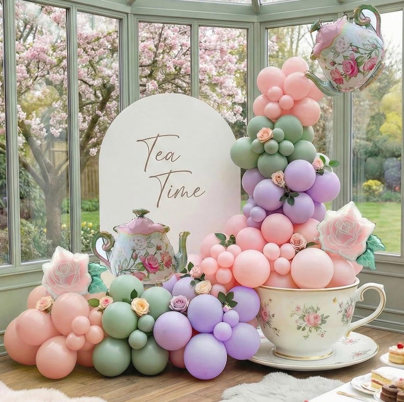 K&ouml;nnte beinhalten: Eine skurrile Teeparty-Szene mit einer gro&szlig;en Teetasse, die mit pastellfarbenen Luftballons &uuml;berquillt. Ein Schild mit der Aufschrift "Tea Time" und ein Teekannen-Ballon schweben dar&uuml;ber. Florale Akzente und eine dekorative Teekanne vervollst&auml;ndigen die Szene.