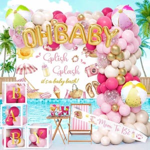 May include: A party decoration set featuring a balloon arch with pink, white, and gold balloons, gold foil 'OH BABY' lettering, and a backdrop with 'Splish Splash it's a baby bash!' text, beach-themed illustrations, and clear display boxes.