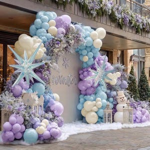 Puede incluir: Una exhibici&oacute;n con tem&aacute;tica invernal con un tel&oacute;n de fondo con la palabra "Winter". La exhibici&oacute;n incluye un arco de globos en tonos azules, morados y blancos, decoraciones en forma de estrella y un mu&ntilde;eco de nieve.