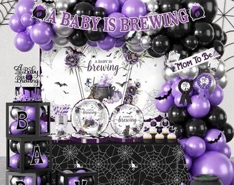 May include: A baby shower party set featuring a balloon arch in purple, black, and silver, a backdrop with a cauldron graphic and the text A BABY IS BREWING, matching plates, a table cover with spiderwebs, and black boxes with letters spelling BABY.