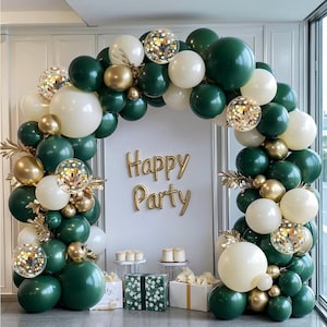 May include: A festive balloon arch in shades of green, white, and gold, with confetti-filled balloons. The words "Happy Party" are displayed in gold. The arrangement includes decorative elements and small cakes, creating a celebratory atmosphere.