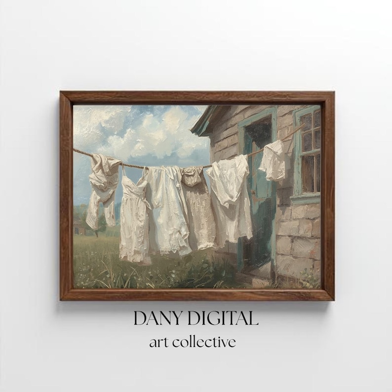 May include: A framed art print of a vintage painting. The artwork shows white clothing hanging on a washing line in front of a weathered building. The sky is blue with fluffy white clouds. The frame is brown, and the text "DANY DIGITAL art collective" is at the bottom.