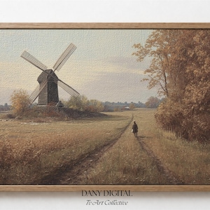 Puede incluir: Impresión enmarcada de un paisaje rural con un molino de viento y un camino. La obra de arte presenta una paleta de colores cálidos, con marrones y dorados, evocando el otoño.