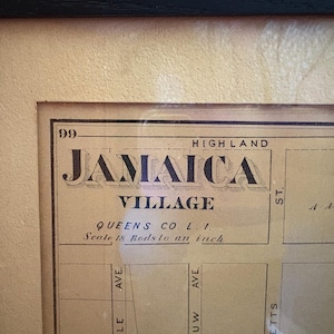 May include: Framed vintage map of Jamaica Village, Queens, NY. The map features the text "JAMAICA VILLAGE" in a decorative font, with street names and a scale of 18 rods to an inch. The map is framed in a black frame.