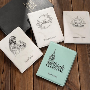 Puede incluir: Una Santa Biblia negra y cuatro fundas rectangulares con nombres y diseños personalizados. Una funda blanca tiene una corona floral y 'Think Celestial', una blanca un sol y 'Think Celestial', una blanca una figura con un cordero, y una funda verde menta muestra un templo con 'Think Celestial'.