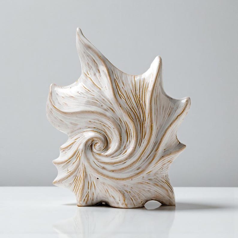 Puede incluir: Una escultura de cer&aacute;mica blanca con un dise&ntilde;o en espiral. La escultura tiene una superficie texturizada con acentos marrones y una forma abstracta &uacute;nica. Es un art&iacute;culo decorativo, adecuado para la decoraci&oacute;n del hogar.