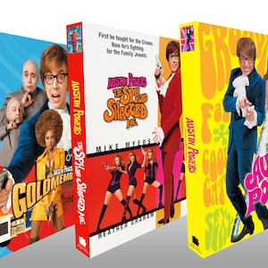 Pode incluir: Três caixas de DVD do filme Austin Powers. A primeira é azul com o título "Goldmember". A segunda é vermelha com o título "The Spy Who Shagged Me". A terceira é amarela com o título "International Man of Mystery".