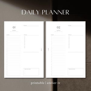 Op de afbeelding: Dubbele pagina van een dagplanner met de tekst "DAILY PLANNER" bovenaan. De linkerpagina is gelabeld "01 januari" en de rechterpagina "02 januari". Elke pagina heeft secties voor afspraken, takenlijsten en notities. De onderkant van de afbeelding luidt "printable | atelier iv".