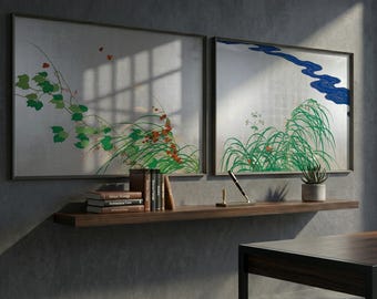 May include: Two framed artworks with Japanese-inspired botanical designs. One features green vines and red berries, the other a blue river and green grass. The frames are dark, and the background is a silver-toned metallic finish.