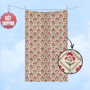 May include: A rectangular textile with a repeating floral pattern of red flowers and green leaves on a cream background. The textile is hanging from a clothesline. A zoomed-in view shows the words "FUCK TRUMP".