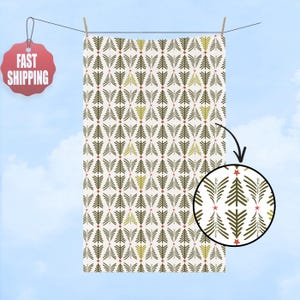 May include: A rectangular fabric with a repeating pattern of stylized green and yellow Christmas trees and red stars on a cream background. The fabric is hanging on a clothesline against a blue sky.