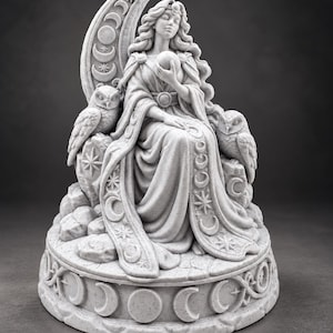 May include: A light gray stone-textured figurine depicting a seated figure holding a sphere, framed by a large crescent moon. Two owls are perched on rocks beside the figure. The circular base features carved lunar phases and star motifs.