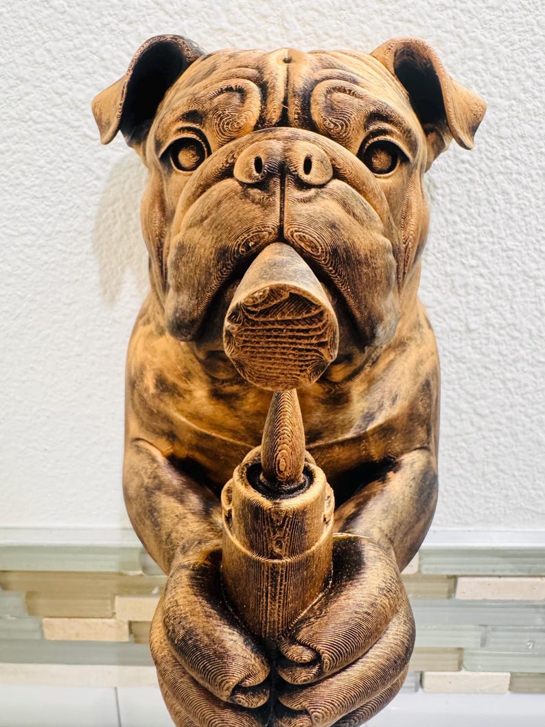 May include: A brown bulldog sculpture holding a candle holder. The bulldog has detailed fur texture and is holding the candle holder with both paws. The sculpture is set against a white wall.