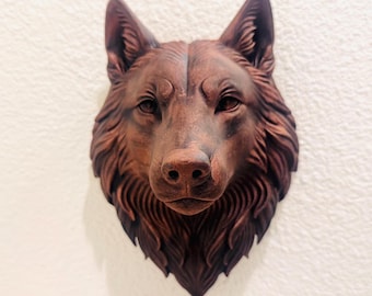Puede incluir: Escultura detallada de una cabeza de lobo marrón montada en una pared blanca. La escultura presenta intrincados detalles del pelaje, los ojos y la nariz del lobo, creando una apariencia realista y texturizada. Una pieza decorativa para la decoración del hogar.