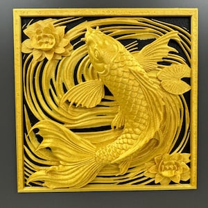 May include: A golden koi fish sculpture with a black background and a gold frame. The fish is surrounded by swirling water and lotus flowers. The sculpture is a 3D relief, showcasing intricate details.