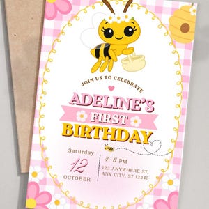 May include: A birthday invitation card featuring a yellow bee character with a white flower crown, a yellow beehive, and pink and white gingham background. The text reads: JOIN US TO CELEBRATE ADELINE'S FIRST BIRTHDAY, Saturday 12 OCTOBER, 4-6 PM, 123 ANYWHERE ST, ANY CITY, ST 12345.