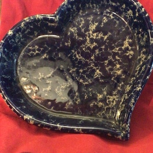 May include: A heart-shaped ceramic serving dish with a blue and white marbled glaze. The dish is perfect for serving snacks, appetizers, or desserts.